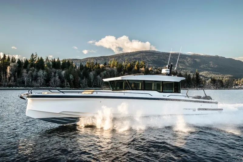 Slide: The Image of 2025 Axopar 37XC CROSS CABIN cruising on a scenic lake with forested hills. - 7
