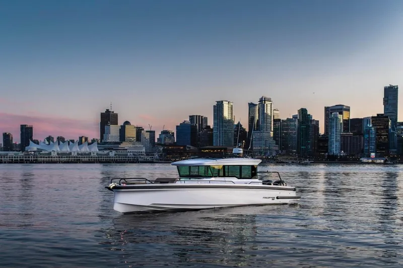 Slide: The Image of 2025 Axopar 37XC CROSS CABIN boat cruising near city skyline at sunset. - 8