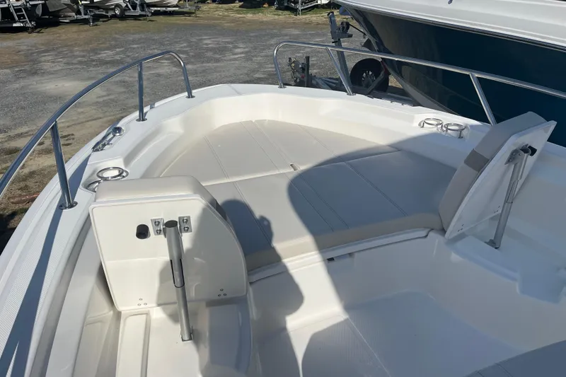 Slide: The Image of 2026 Boston Whaler 250 Dauntless boat interior with cushioned seating and stainless steel railings. - 18