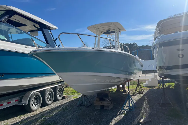 Slide: The Image of 2026 Boston Whaler 250 Dauntless boat displayed outdoors on stands. - 22