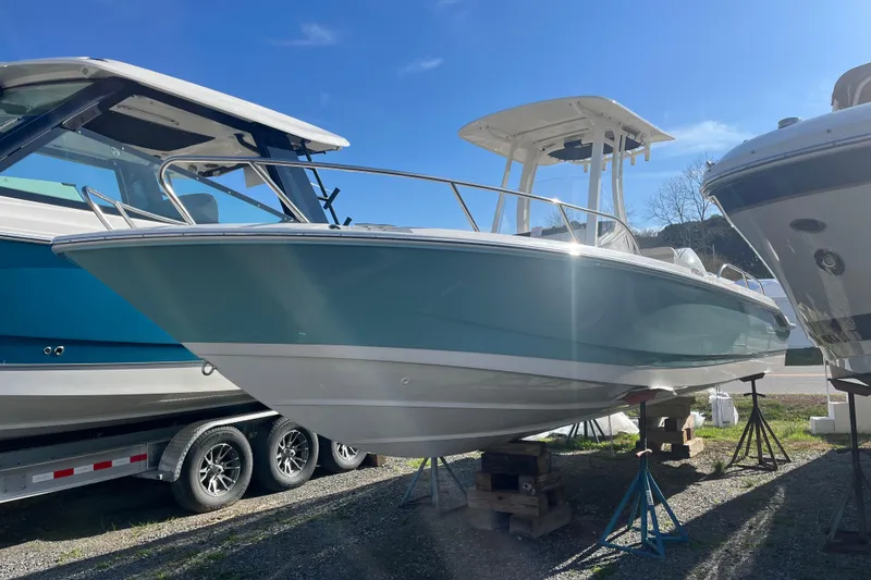 Slide: The Image of 2026 Boston Whaler 250 Dauntless boat displayed outdoors on stands. - 23