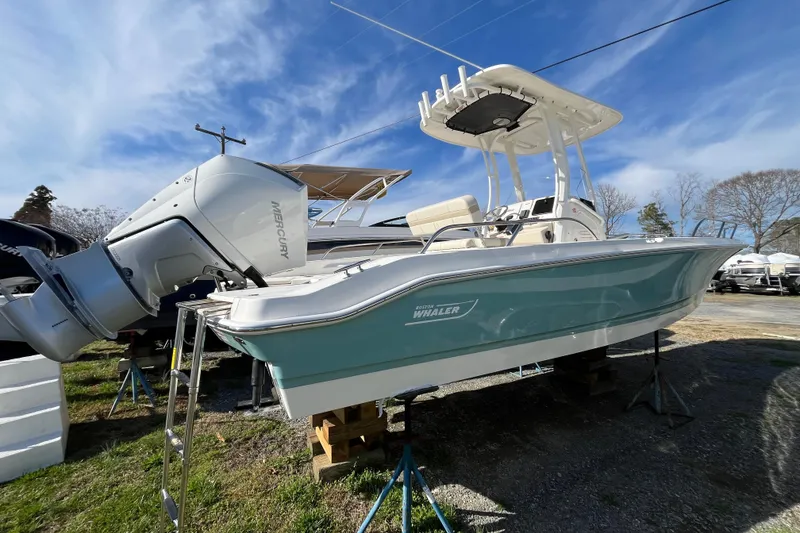 Slide: The Image of 2026 Boston Whaler 250 Dauntless boat with Mercury engine, displayed outdoors under blue sky. - 28