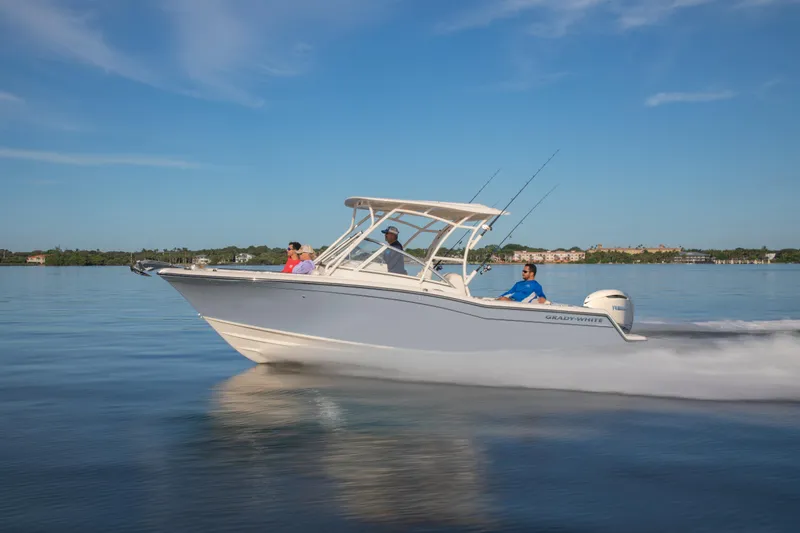 Slide: The Image of 2025 Grady-White 235 Freedom boat cruising on calm water, clear sky background. - 1
