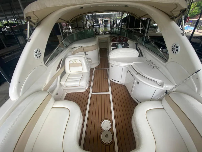 Slide: The Image of 2003 Sea Ray 290 Bowrider interior with white seating and wood flooring. - 12