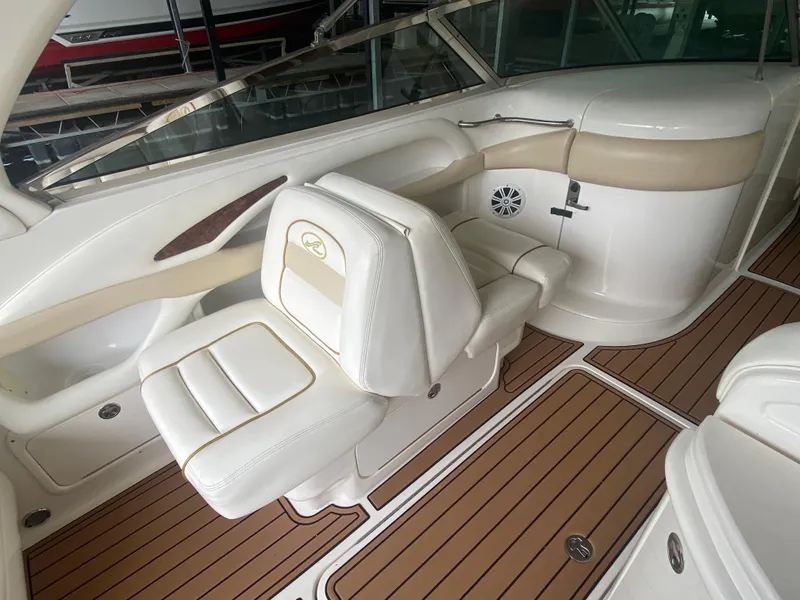 Slide: The Image of 2003 Sea Ray 290 Bowrider interior with white seating and wood-style flooring. - 18