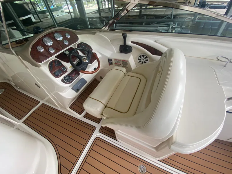 Slide: The Image of 2003 Sea Ray 290 Bowrider cockpit with wood accents and cream seating. - 19