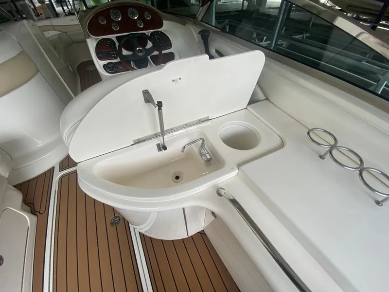 Slide: The Image of 2003 Sea Ray 290 Bowrider interior with sink, cup holders, and steering console. - 20
