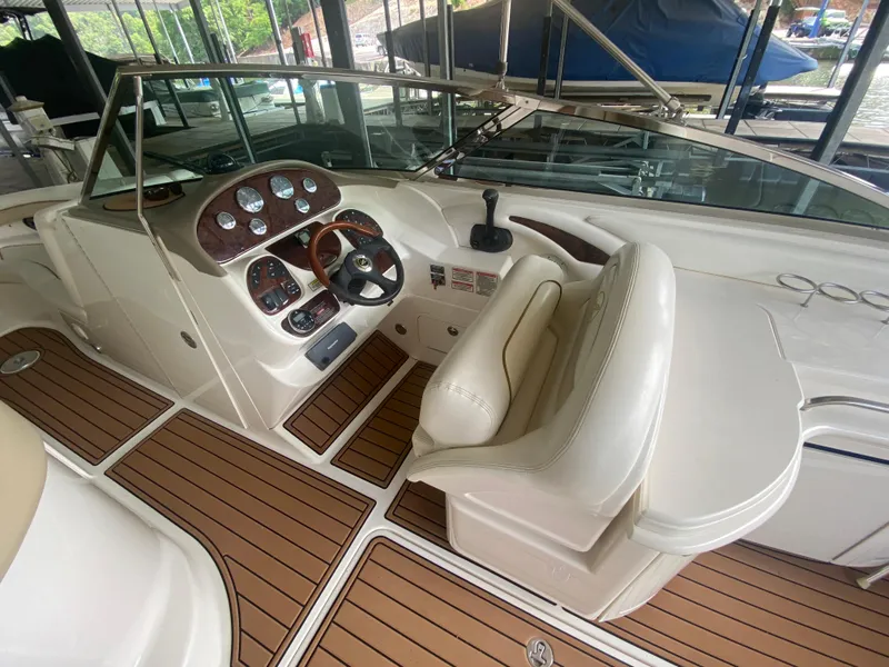 Slide: The Image of 2003 Sea Ray 290 Bowrider cockpit with steering wheel, gauges, and cushioned seating. - 21