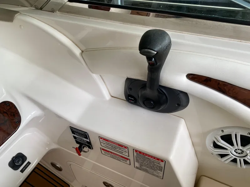 Slide: The Image of 2003 Sea Ray 290 Bowrider control panel with throttle lever and warning labels. - 23