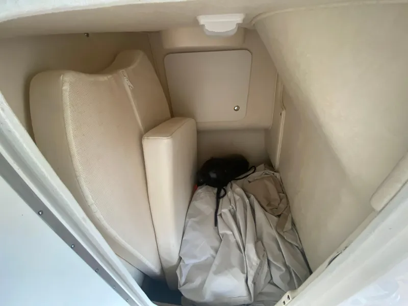 Slide: The Image of Interior cabin of 2003 Sea Ray 290 Bowrider with beige cushions and storage space. - 26