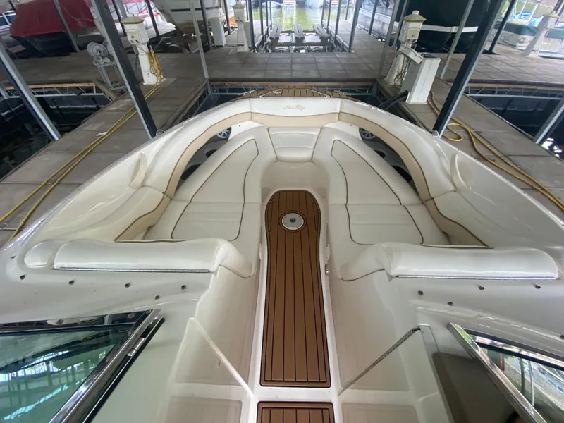 Slide: The Image of 2003 Sea Ray 290 Bowrider with spacious seating and elegant wood flooring in a marina. - 27