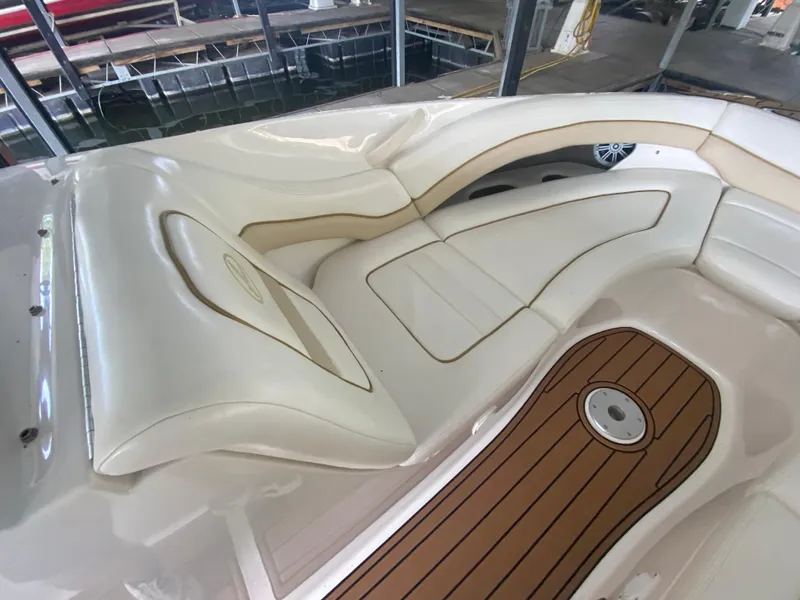 Slide: The Image of 2003 Sea Ray 290 Bowrider interior with white seating and wood-style flooring. - 28