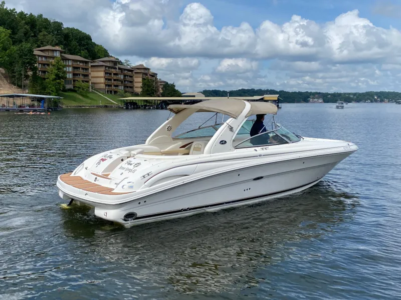 Slide: The Image of 2003 Sea Ray 290 Bowrider cruising on a lake with scenic shoreline views. - 5