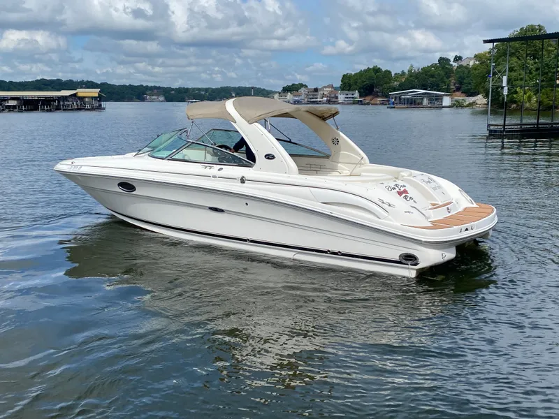Slide: The Image of 2003 Sea Ray 290 Bowrider on a calm lake under a partly cloudy sky. - 6