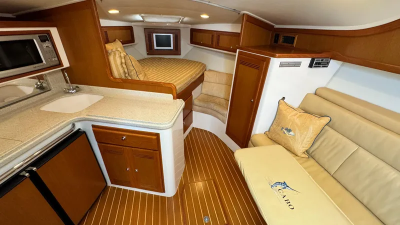 Slide: The Image of Luxurious interior of 2005 Cabo 35 Express yacht with kitchenette and cozy seating area. - 12