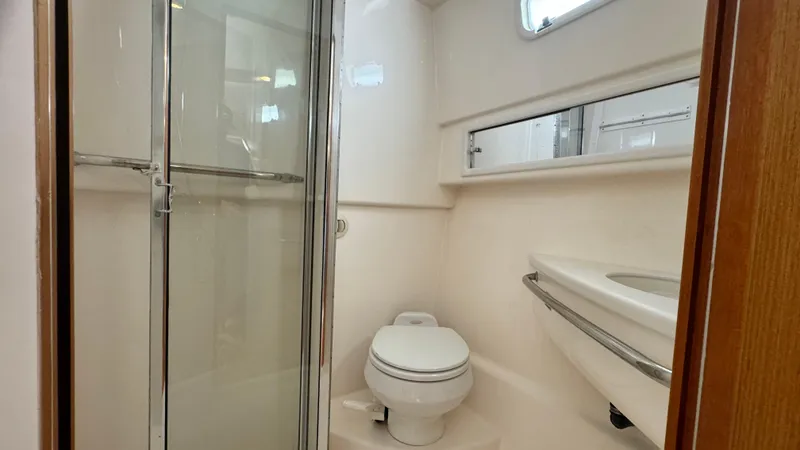 Slide: The Image of 2005 Cabo 35 Express yacht bathroom with shower, toilet, and sink. - 13