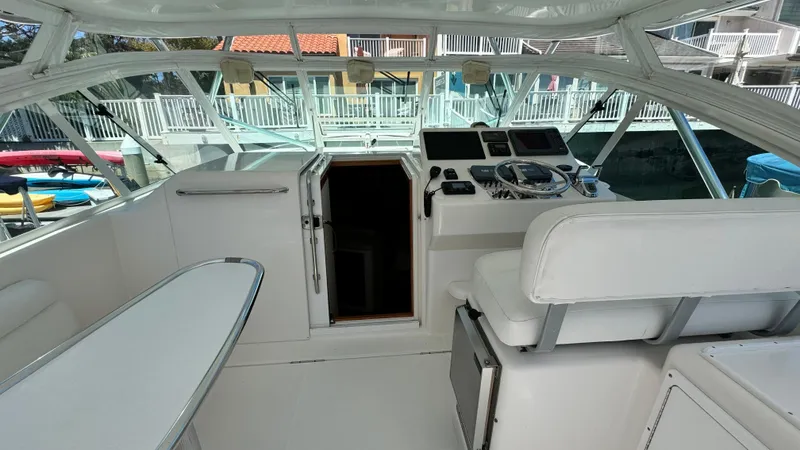 Slide: The Image of 2005 Cabo 35 Express boat interior with helm, seating, and open cabin door. - 6
