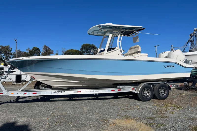 Slide: The Image of 2026 Boston Whaler 280 Dauntless boat on trailer, light blue hull, clear sky background. - 28