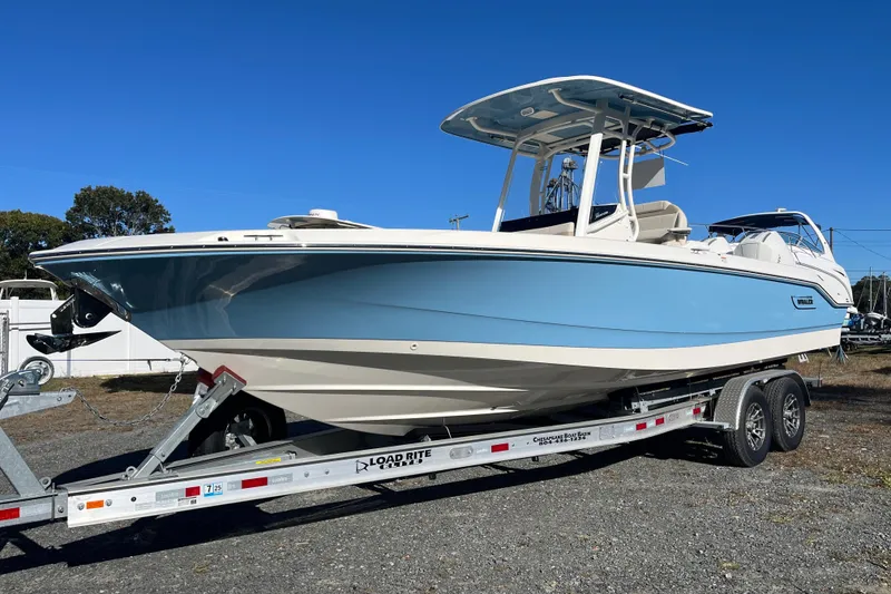 Slide: The Image of 2026 Boston Whaler 280 Dauntless boat on trailer, light blue hull, sunny day. - 29