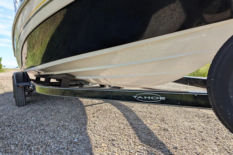 Slide: The Image of 2006 Tahoe Q6 Sport boat on trailer, side view, parked on gravel. - 10