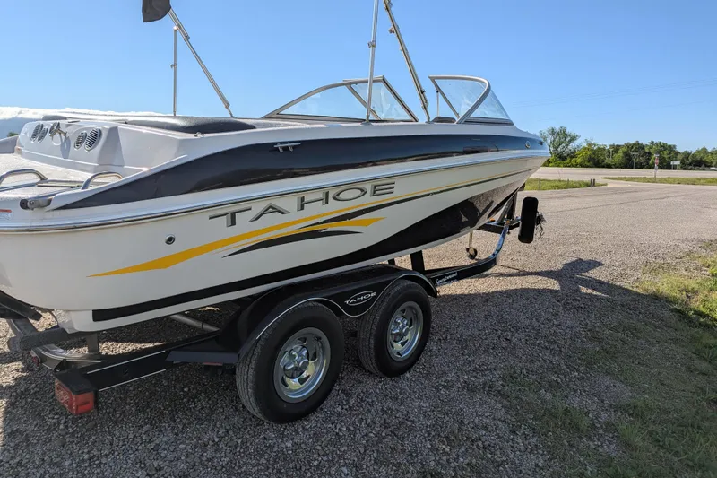 Slide: The Image of 2006 Tahoe Q6 Sport boat on trailer, parked on gravel under clear blue sky. - 7