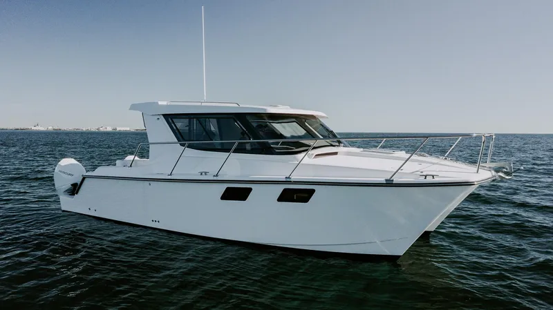 Slide: The Image of 2025 ArrowCat 320 boat cruising on open water under clear skies. - 15