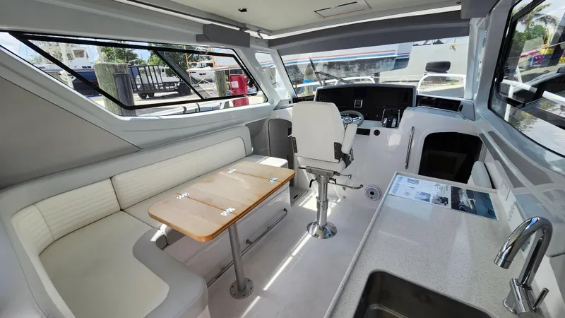 Slide: The Image of Interior of 2025 ArrowCat 320 boat with seating, helm, and kitchenette. - 3