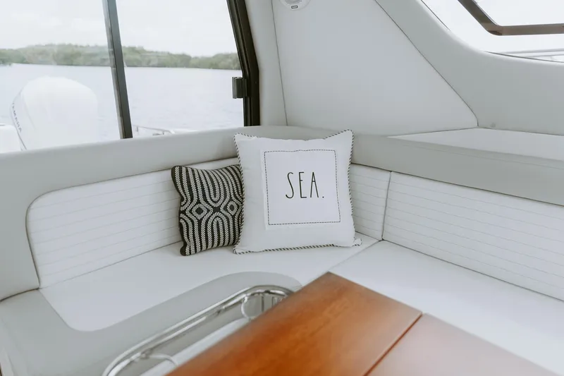 Slide: The Image of Luxurious interior of 2025 ArrowCat 320 boat with decorative pillows and wooden table. - 4