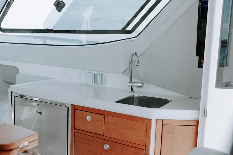 Slide: The Image of Modern kitchen area in 2025 ArrowCat 320 boat with sink and wooden cabinets. - 6
