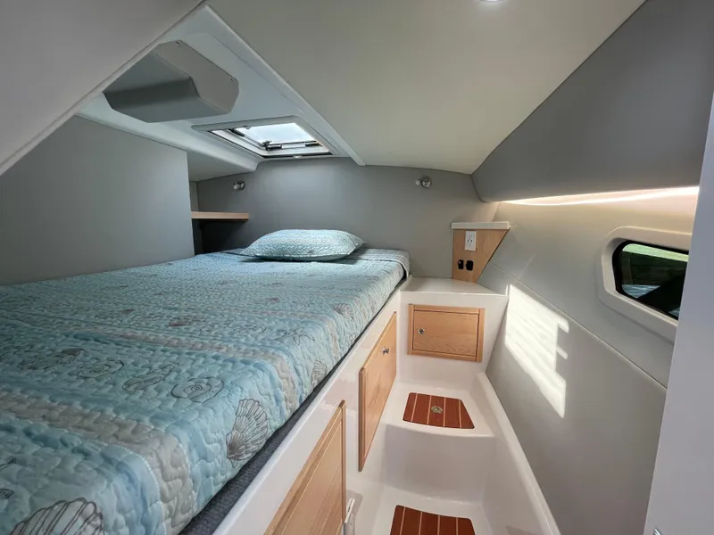 Slide: The Image of Cozy cabin interior of 2025 ArrowCat 320 with bed, skylight, and storage. - 8