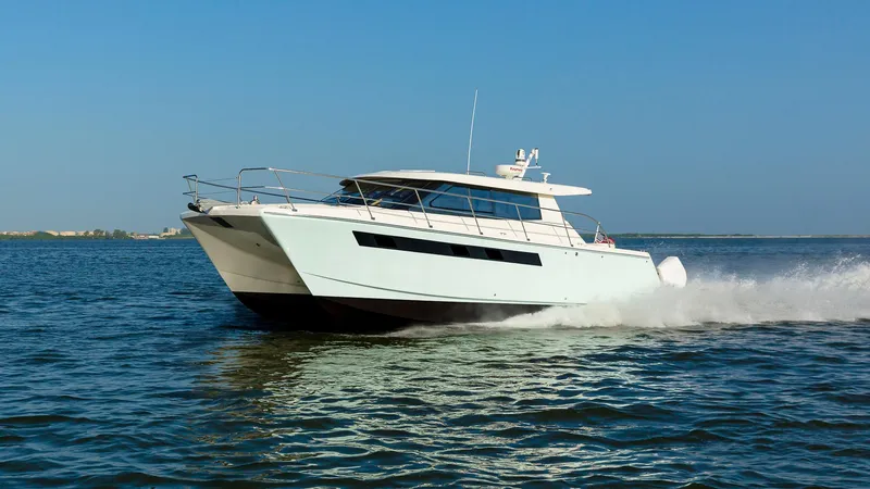 The Image of 2025 ArrowCat 420 Coupe cruising on open water under clear blue skies. - 0