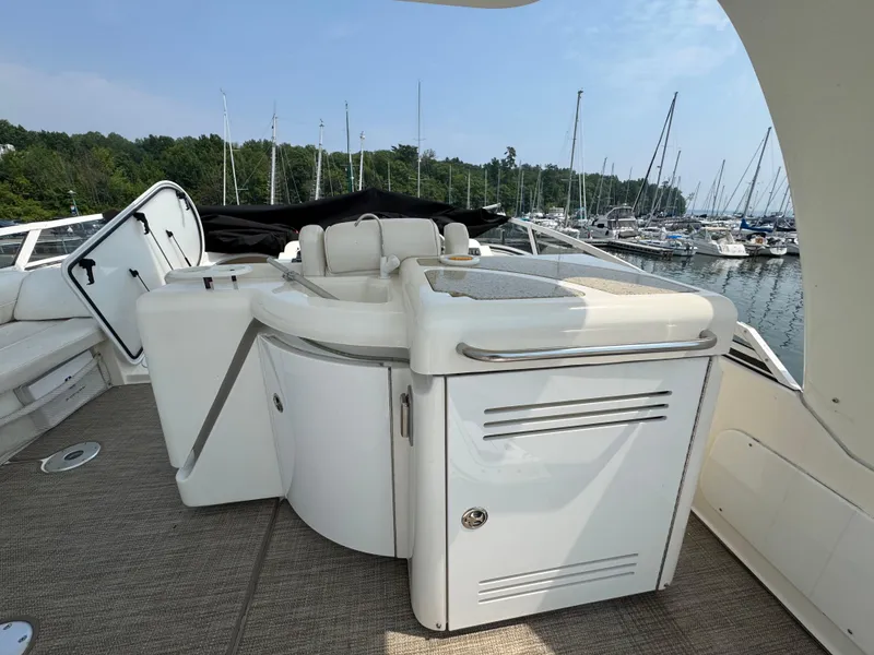 Slide: The Image of 2003 Cruisers Yachts 5000 Sedan Sport deck with seating, docked at marina. - 11