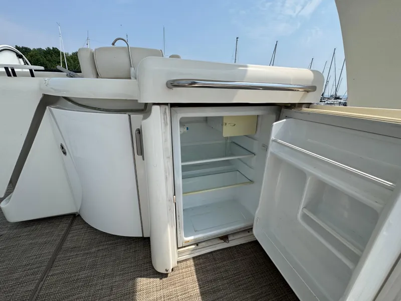 Slide: The Image of Open fridge on 2003 Cruisers Yachts 5000 Sedan Sport, showcasing interior storage space. - 13