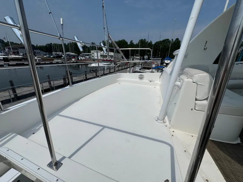 Slide: The Image of 2003 Cruisers Yachts 5000 Sedan Sport deck, docked at marina under clear sky. - 14