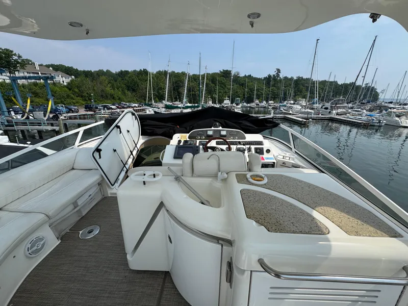 Slide: The Image of 2003 Cruisers Yachts 5000 Sedan Sport at marina, featuring helm and seating area. - 16