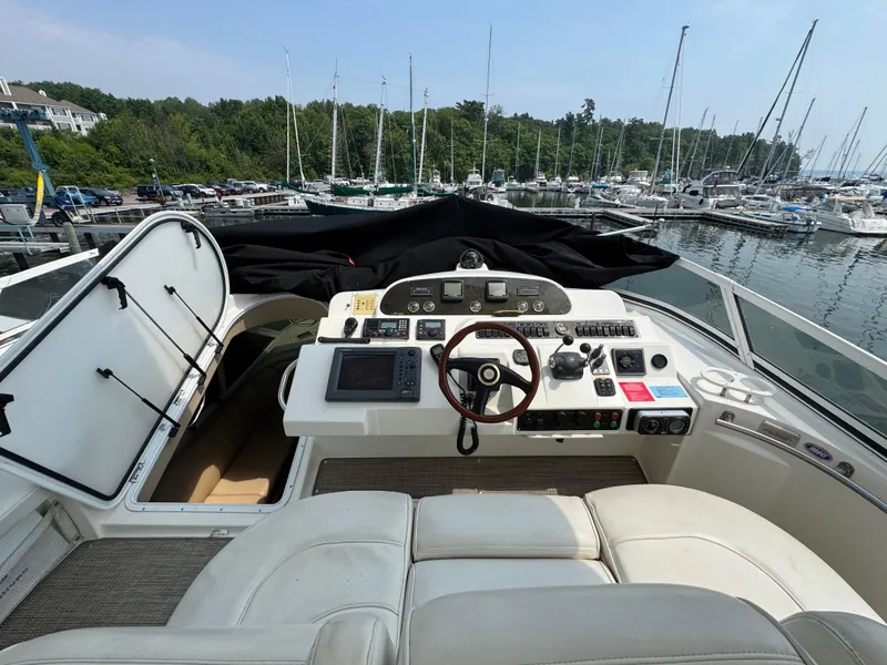 Slide: The Image of 2003 Cruisers Yachts 5000 Sedan Sport helm with marina view in the background. - 18