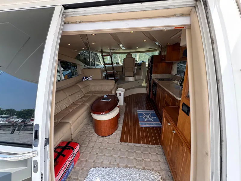 Slide: The Image of Luxurious interior of 2003 Cruisers Yachts 5000 Sedan Sport with leather seating and wooden cabinetry. - 31