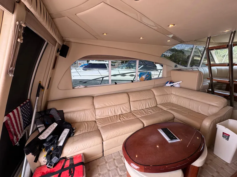 Slide: The Image of Luxurious interior of 2003 Cruisers Yachts 5000 Sedan Sport with leather seating and wooden table. - 34