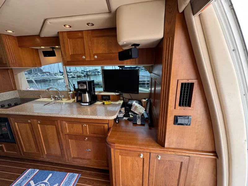 Slide: The Image of Luxurious 2003 Cruisers Yachts 5000 Sedan Sport interior with wooden cabinetry and modern amenities. - 36