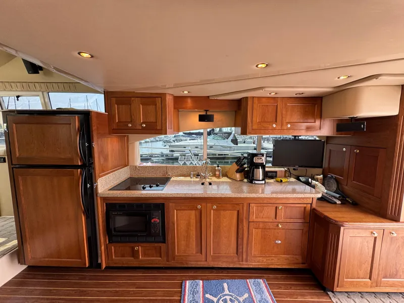 Slide: The Image of Luxurious kitchen interior of 2003 Cruisers Yachts 5000 Sedan Sport with wooden cabinetry. - 38