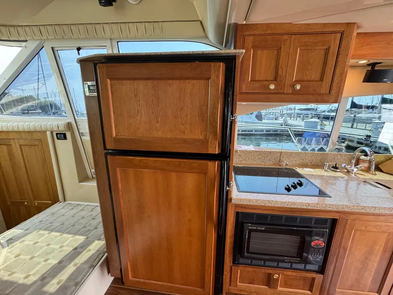 Slide: The Image of 2003 Cruisers Yachts 5000 Sedan Sport kitchen with wood cabinetry and modern appliances. - 39