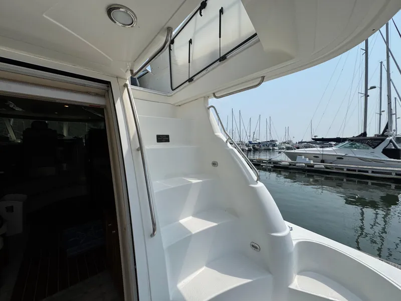 Slide: The Image of 2003 Cruisers Yachts 5000 Sedan Sport, staircase view, docked at marina with boats. - 8