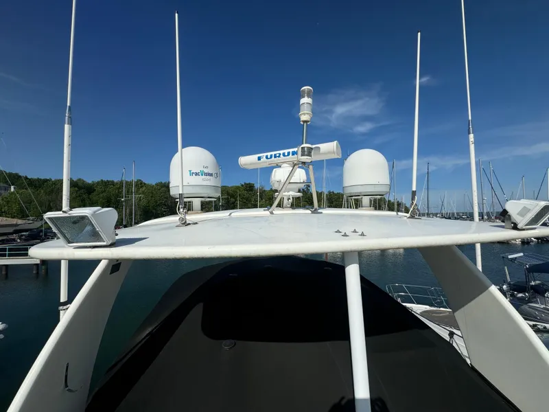 Slide: The Image of 2003 Cruisers Yachts 5000 Sedan Sport with radar equipment, docked in a marina under clear skies. - 92