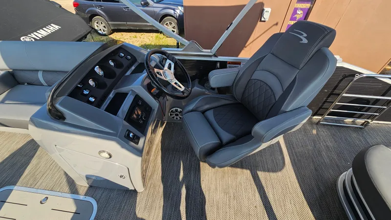 Slide: The Image of 2020 Bennington SX 23 Premium Swingback boat interior with steering console and captain's chair. - 11