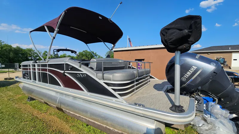 Slide: The Image of 2020 Bennington SX 23 Premium Swingback pontoon boat with Yamaha engine, parked outdoors. - 2
