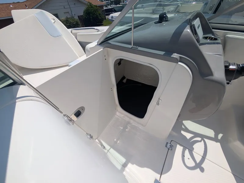 Slide: The Image of 2025 Robalo R207 Dual Console boat interior with open storage compartment. - 15