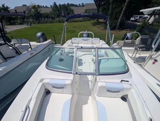 Slide: The Image of 2025 Robalo R207 Dual Console boat with open deck and seating, docked outdoors. - 4