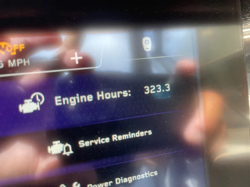 Slide: The Image of Display screen showing 323.3 engine hours on 2021 Nautique Super Air Nautique G25 Paragon. - 13