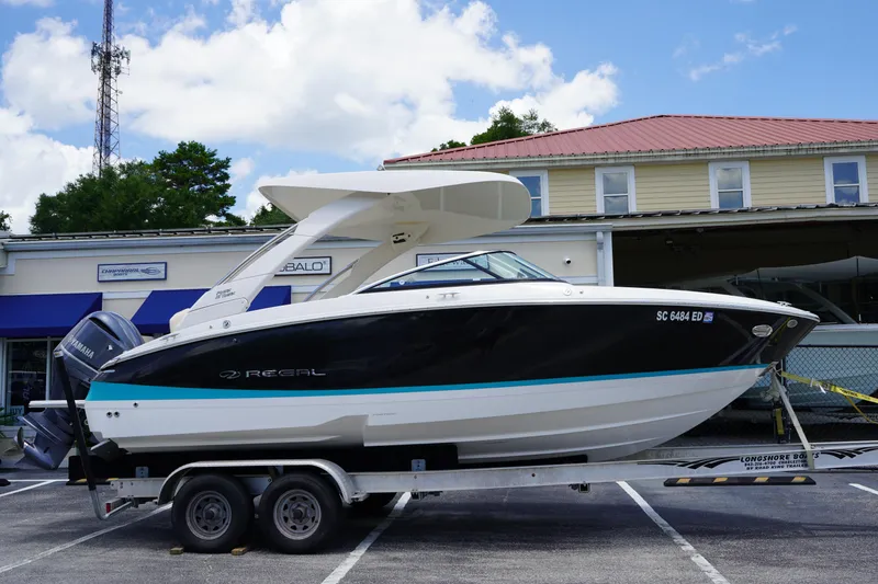 The Image of 2023 Regal LX4 boat on trailer in parking lot, sunny day. - 0