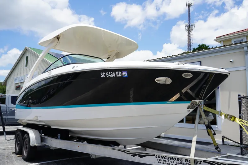 Slide: The Image of 2023 Regal LX4 boat on trailer, black and white design, outdoor display. - 1